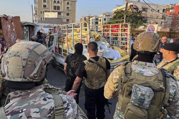 Army soldiers stand next to a pickup carrying weapons handed over by Palestinian factions at the Burj al-Barajneh Palestinian refugee camp in Beirut, Lebanon, Thursday, Aug. 21, 2025, in an initial step to implement a plan officials announced three months earlier for removing arms from the camps. (AP Photo/Hussein Malla)