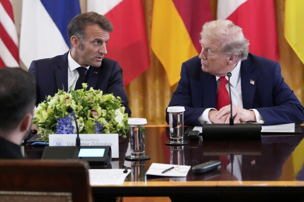 France's President Emmanuel Macron, left, and President Donald Trump speak during a meeting in the East Room of the White House with Ukrainian President Volodymyr Zelenskyy, Monday, Aug. 18, 2025, in Washington. (AP Photo/Alex Brandon)