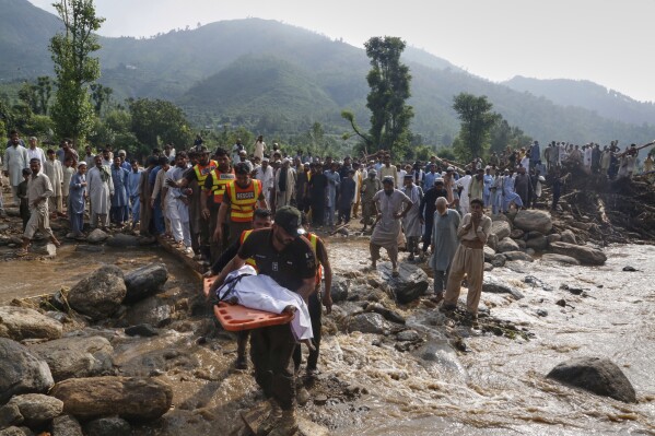Rescue workers transport the body a victim of Friday's flash flooding after recovering it from the rubble of a damaged house at Qadir Nagar village near Pir Baba, Buner district, in Pakistan's northwest, Saturday, Aug. 16, 2025. (AP Photo/Muhammad Sajjad)