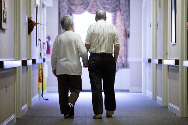 An elderly couple walks down a hallway in Easton, Pa., on Nov. 6, 2015. (AP Photo/Matt Rourke, File)