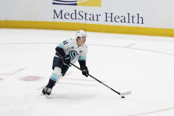 Seattle Kraken defenseman Ryker Evans skates with the puck during the third period of an NHL hockey game against the Washington Capitals, March 9, 2025, in Washington. (AP Photo/Terrance Williams, File)