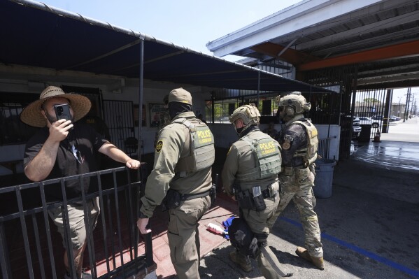 Agentes de inmigración realizan una operación en un lavado de autos, el 15 de agosto de 2025, en Montebello, California (AP Foto/Gregory Bull)