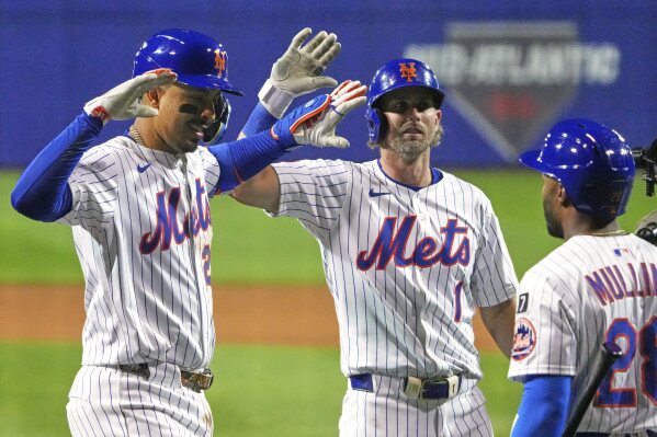 New York Mets third base Mark Vientos, left, is greeted by Jeff McNeil (1), and Cedric Mullins (28) as he returns to the dugout after hitting a three-run home run off Seattle Mariners pitcher George Kirby during the fifth inning of the Little League Classic baseball game at Bowman Field in Williamsport, Pa., Sunday, Aug. 17, 2025. (AP Photo/Gene J. Puskar)