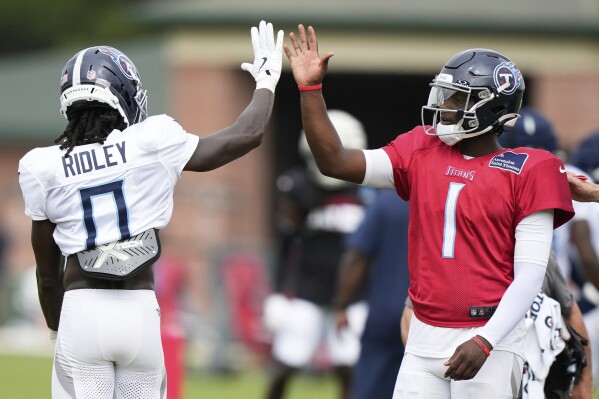 Tennessee Titans quarterback Cameron Ward (1) high fives Tennessee Titans wide receiver Calvin Ridley (0) during an NFL joint football practice with the Atlanta Falcons on Tuesday, Aug. 12, 2025, in Flowery Branch, Ga. (AP Photo/Brynn Anderson)