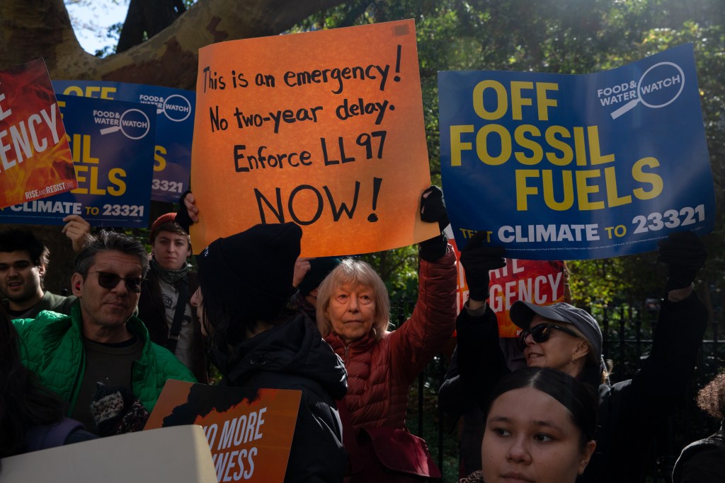 Environmental advocates rally outside City Hall in favor of enforcing new building emission standards.
